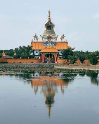 Buddhist stupa with reflection in water at a temple in Nepal