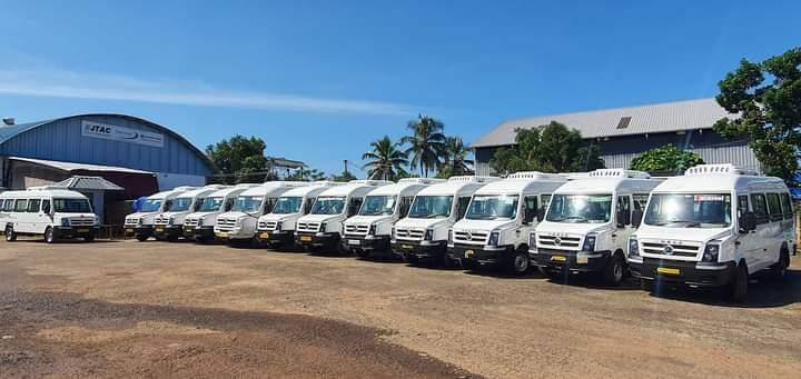Fleet of tourist tempo travelers parked at depot.