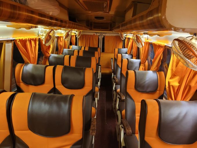 Tourist bus from Gorakhpur to Nepal with modern facilities like cushioned reclining seats, air conditioning, large windows for sightseeing, and overhead storage for passenger convenience.